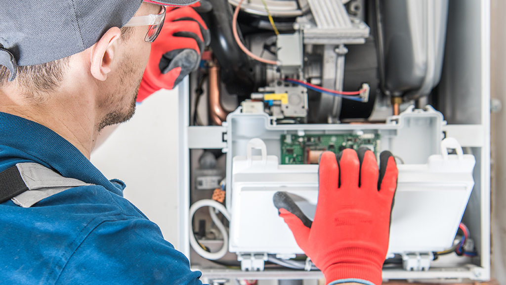 Technician Trying To Fix the Problem with the Residential Heating Equipment.